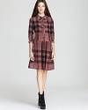 A drop-waist silhouette lends a new season spin to the classic Burberry Brit check dress, styled with edgy boots for a thoroughly modern statement.