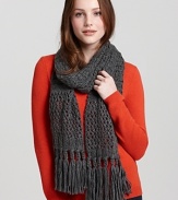 Bundle up in a thick cable knit scarf with long fringed edges.