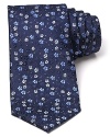 Adorned with a pattern of tonal flowers on a slightly textured background, this luxuriously soft tie freshens up your professional wardrobe with a dash of rich color.