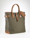 A superior carryall for daily essentials, a polished canvas bag is constructed with saddle-inspired leather trim and comfortable rolled handles and features organizational interior pocketing for quick access to the necessities.