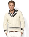 Fashioned in a heritage cable knit from luxe Italian cotton, a classic V-neck sweater is adorned with cricket stripes and herringbone wool elbow patches for authentic style.