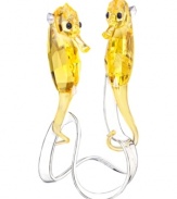 A long way from the ocean, these enchanting seahorses sparkle in clear and faceted yellow Swarovski crystal. Featuring a silvertone metal stand reminiscent of their underwater world.