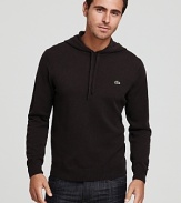 A long sleeve Lacoste hoodie with a signature alligator logo.