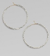 Hoops of 14k gold wire are set with faceted sterling silver beads that catch and reflect light with a warm radiance.14k yellow gold and sterling silverDiameter, about 1½Ear wireMade in USA