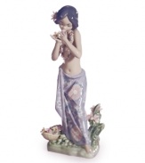 Hawaii beckons. A young hula dancer stops to smell the orchids in this fanciful collectible, handcrafted in exquisite Lladro porcelain.