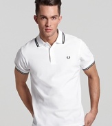 Widely known as the pioneer of Mod, British street fashion, Fred Perry polos have become an iconic fashion silhouette. A sporty polo with contrast double stripe trim and embroidered logo at left chest. Slim fit.