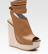 Chic, platform wedge style emboldened by a leather, wrap-around ankle strap. Wooden wedge, 5 Covered platform, 1½ Compares to a 2½ heel Leather upper Peep toe Leather lining Rubber sole Made in ItalyOUR FIT MODEL RECOMMENDS ordering one size up as this style runs small. 