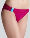 A vibrant magenta hue glows against cool, turquoise-tinted stones on PilyQ's saturated Santa Clara bikini.