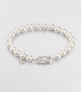 A lustrous strand of cultured pearls accented with a feminine 18k white gold clasp. 7mm-7.5mm round white cultured pearls18k white goldLength, about 7Butterfly closureImported 