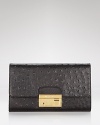 Michael Kors' convertible clutch brings the versatility after dark. Dual purpose, this ostrich-embossed bag is equally chic over the shoulder or tucked under a well-dressed arm.