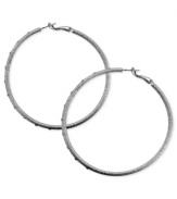 A stylish must-have. These clutchless hoop earrings from GUESS feature a diamond dust design with glass stones. Crafted in silver tone mixed metal. Approximate diameter: 2-1/2 inches.