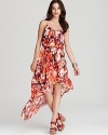 From the vibrant floral print to the dramatic high/low hem, this GUESS dress is sure to delight the season.