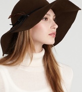 A fabulous wool felt floppy hat with a feather accent brings boho style to your favorite ensemble.