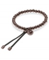 Slip-on stackable style! Michael Kors' chic stretch bracelet brings espresso tone beads and logo accents. Finished with espresso-tone mixed metal tipped, adjustable leather clasp. Approximate diameter: 2-1/4 inches.