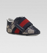 A wide strap in familiar Gucci stripes crosses over a refined sneaker of double G fabric with rich leather accents.GG fabric upperLeather toe, back and accentsWide, striped grip-tape close strapRubber soleMade in Italy