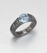 A simple, square-edged band is channel-set with an icy cool mix of blue sapphire, white topaz and blue topaz stones, creating an elegant showcase for a faceted pastel blue topaz.Sapphires, white topaz and blue topazBlack rhodium-plated sterling silverWidth, about .7Imported