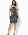 Rendered in a sleek metallic jacquard, the strapless dress exudes sophisticated evening glamour.