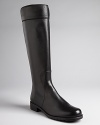 Stuart Weitzman gives these riding boots minimalist design with maximum style impact. Black leather seaming at cuffs finishes off the look.