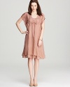 An understated blush makes a dramatic appearance on this ruffled Eileen Fisher dress. A cinched bust and delicate dipped hem lend romantic appeal.