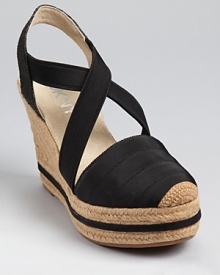 DKNY takes a sporty stance on the espadrille, trimming it with elastic and grosgrain details and a striped detail at the sole.