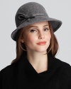 A wool cloche hat with a wide front brim and bow accent creates a flattering silhouette and chic style.