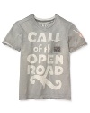 GUESS updates this tee with raw hem insets, bleached-out print across the front and a large logo patch at left sleeve.