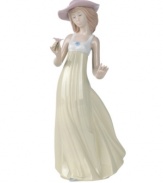 A picture-perfect still of grace and beauty, this handmade porcelain figure presents a young belle admiring a flower as her dress flutters behind; an ideal gift that sparks care-free joy within any special someone.