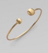 From the Africa Collection. Two 18k yellow gold orbs bookend this open bangle design.18k yellow gold Diameter, about 7 Made in Italy 