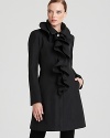 A flirty spray of cascading ruffles enliven this modern Elie Tahari trench coat with an extra feminine touch.