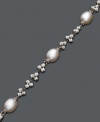 A traditional pearl bracelet with an intricate spin. Bracelet features cultured freshwater pearls (8-9 mm) strung on a sterling silver chain accented with clusters of sparkle beads. Approximate length: 7 inches.