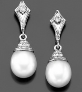 Majestic elegance: cultured freshwater pearl (7-7-1/2 mm) drop earrings with shimmering diamond accents in a 14k white gold setting. Approximate length: 3/4 inch.