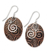 You'll be entranced by Jody Coyote's hypnotic style. Swirls of sterling silver combine with engraved copper on these oval-shaped drop earrings. Approximate drop: 1-1/2 inches.