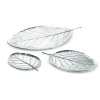 The whimsical beauty of these polished aluminum trays relies on the seamless mixture of organic form and modern material, a signature of American metal designer Michael Aram. The sizes of the leaf trays are: large (shown top) - 17x10, medium (shown bottom right) - 11x8, small (shown bottom left) - 7.75x5.5.