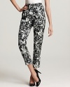 Patterned with black and grey florals, these tapered Theory pants come complete with a ruffled waistline for fabulously feminine flair. Emulate the runway with a tucked-in blouse and your favorite pointy-toe stilettos.