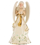 An ethereal figure draped in ivory and gold, this porcelain angel from Lenox is a beacon of hope throughout the holidays. Pierced accents reveal a light from within.