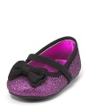 Stuart Weitzman brings you a dazzling pair of pink glitter flats, accented with black bows and ankle straps.