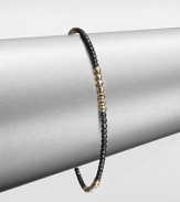 A simple chic piece that features faceted beads in blackened sterling silver accented with four, 14k gold beaded sections. Blackened sterling silver14k goldDiameter, about 2.5Slip-on styleMade in USA