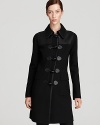 Cut a sharp silhouette in this DKNY coat, flaunting sleek tailoring and clean lines for modern sophistication. Leather insets finish the style with downtown edge.