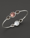 Faceted doublets of clear quartz, almond and mother-of-pearl in a sterling silver bangle. By Ipploita.