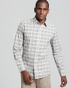 A large plaid print in light gray stylishly elevates a slim fit button down from Theory.