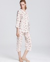 Lounge around in style with this classic three-quarter sleeve top and capri pajama pants featuring a pretty floral print.