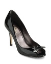 A daring peeptoe in polished patent leather finished with a bow and Cole Haan's signature gold tip details.