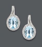 Polish your look with the perfect pair. These elegant oval drop earrings feature a oval-cut blue topaz (3-1/10 ct. t.w.) surrounded by glittering diamond accents. Set in sterling silver. Approximate drop: 3/4 inch.