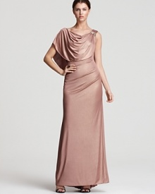 A draped overlay lends elegance to this shimmering Badgley Mischka gown, embellished with opulent jewels at the shoulder.