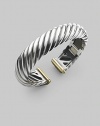 From the Carved Cable Collection. A bold cable cuff of sterling silver, richly accented with touches of 18k gold. Sterling silver and 18k yellow gold Cable, 15mm Diameter, about 2¼ Hinged Imported