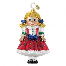 A Christmas doll ornament shines in a bright red jumper and blue bows.