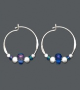 Petite hoops with a lot of character. These sterling silver hoops by Jody Coyote feature silver accents beads and light blue Czech glass beads. Approximate size: 5/8 inch x 3/4 inch.