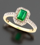 Strikingly beautiful with a bold emerald-cut emerald (3/8 ct.t.w.) surrounded with the beauty of sparkling round-cut  diamonds (1/8 ct. t.w.), all set in 14K yellow gold.