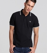 Widely known as the pioneer of Mod, British street fashion, Fred Perry polos have become an iconic fashion silhouette. A sporty polo with contrast double stripe trim and embroidered logo at left chest. Slim fit.