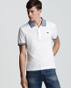 Thin stripes at the collar and sleeve edge differentiate this cool Lacoste polo from a crowded sea of pique solids.